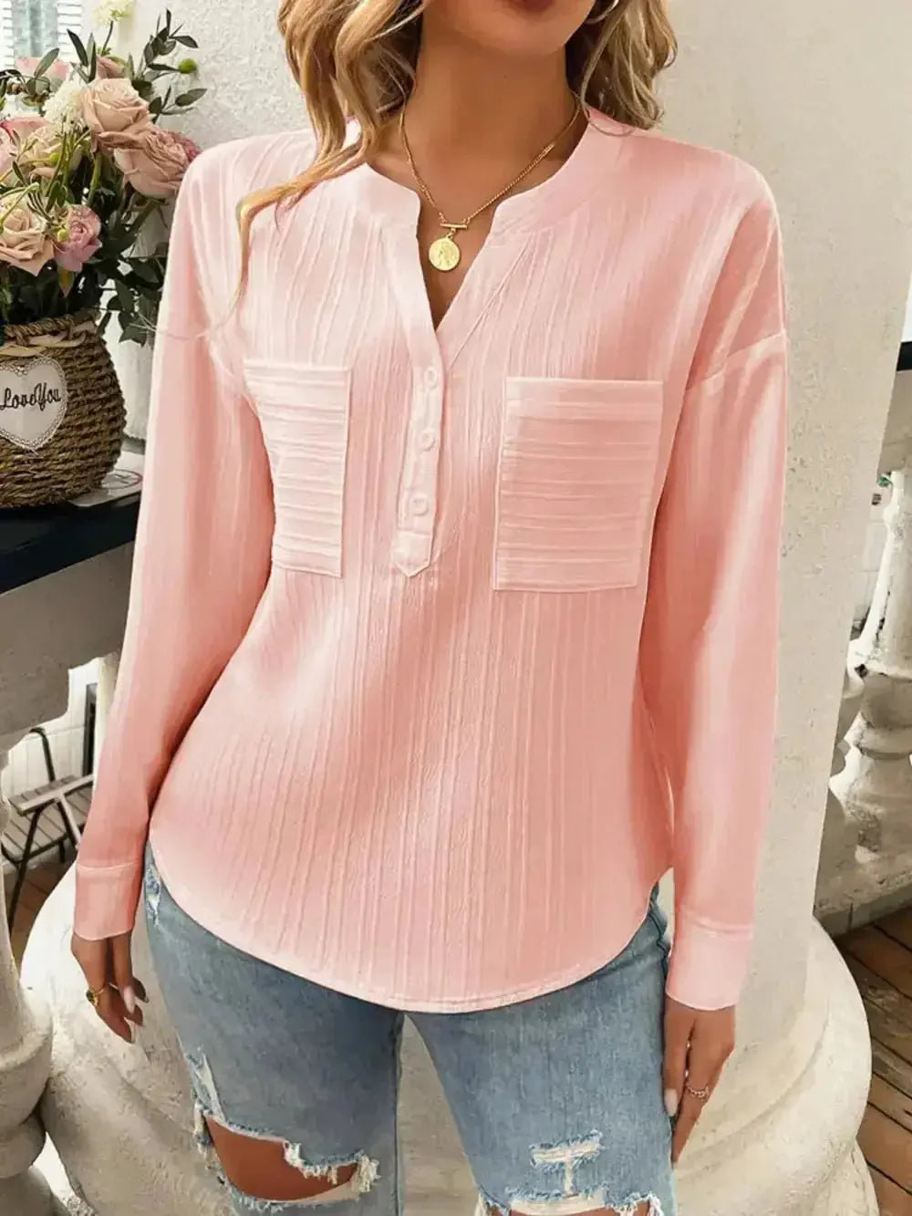 Pink long sleeve button-up blouse with front pockets, paired with ripped jeans for casual women's fashion