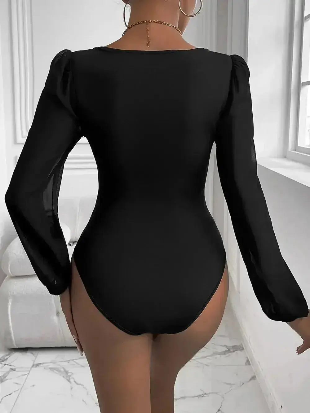 Black long-sleeve bodysuit with puff sleeves, modern minimalist women's fashion