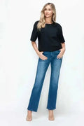 Woman wearing black tee and blue flare jeans, modern minimalist women's fashion outfit