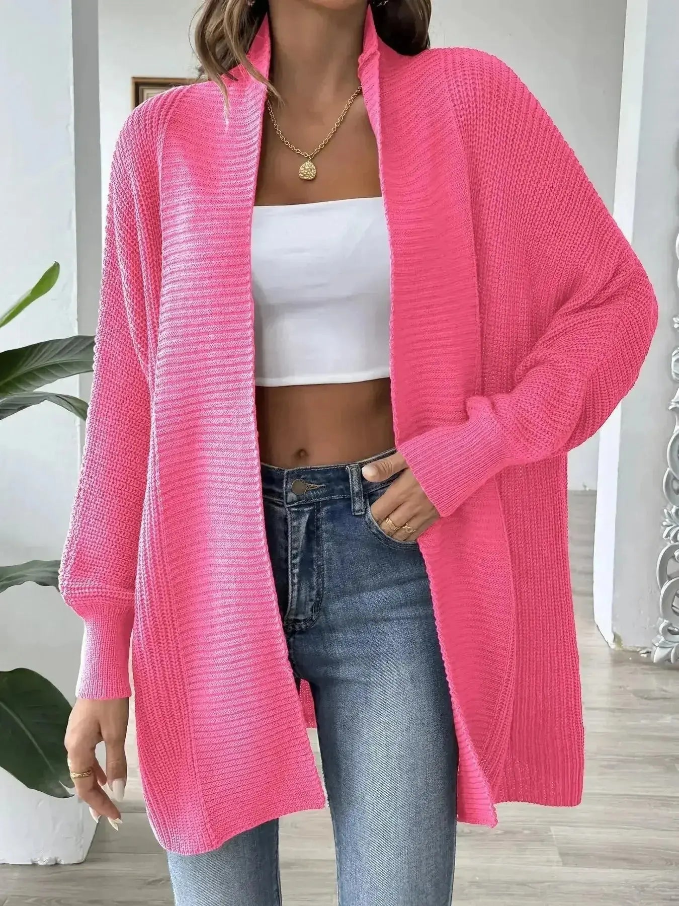 Pink ribbed knit cardigan for women, styled with white crop top and jeans, modern minimalist fashion