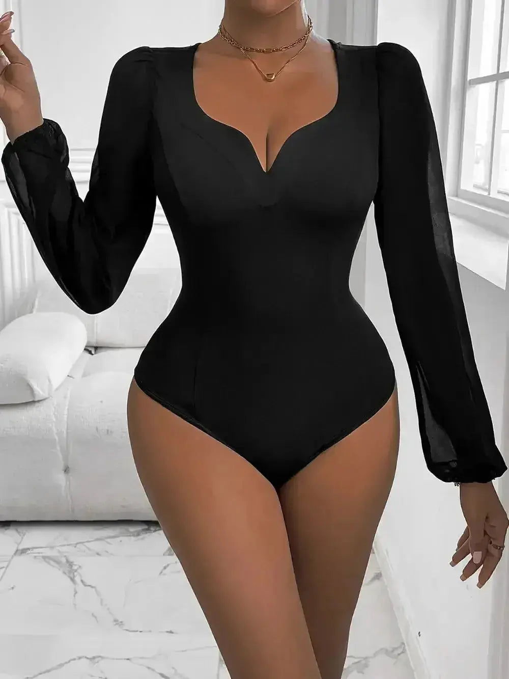 Black long-sleeve bodysuit with deep V-neck and sheer sleeves, modern minimalist women's fashion