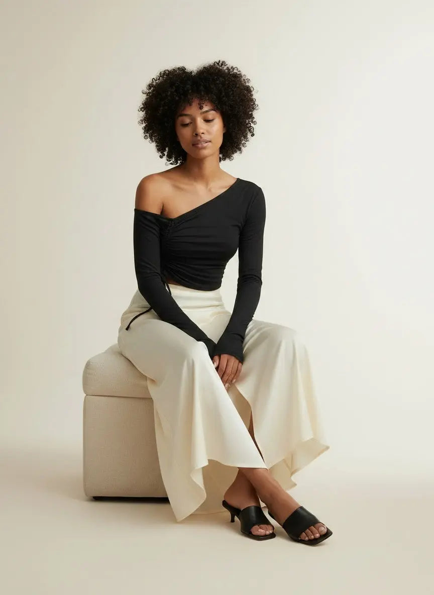 Model sitting while wearing Ivy Lane Asymmetrical Long Sleeve Side Tie Blouse