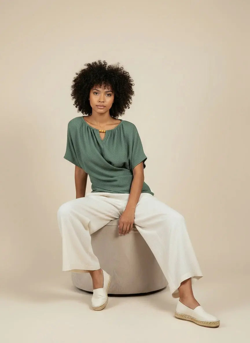 Model sitting while wearing Beaded Neckline Short Sleeve Blouse