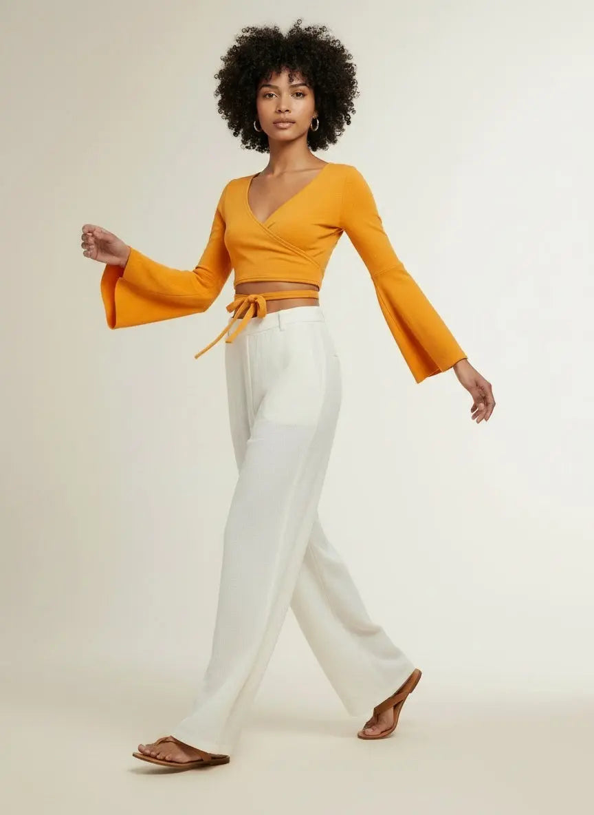 Model walking while wearing Tie Front Flare Sleeve Cropped Top