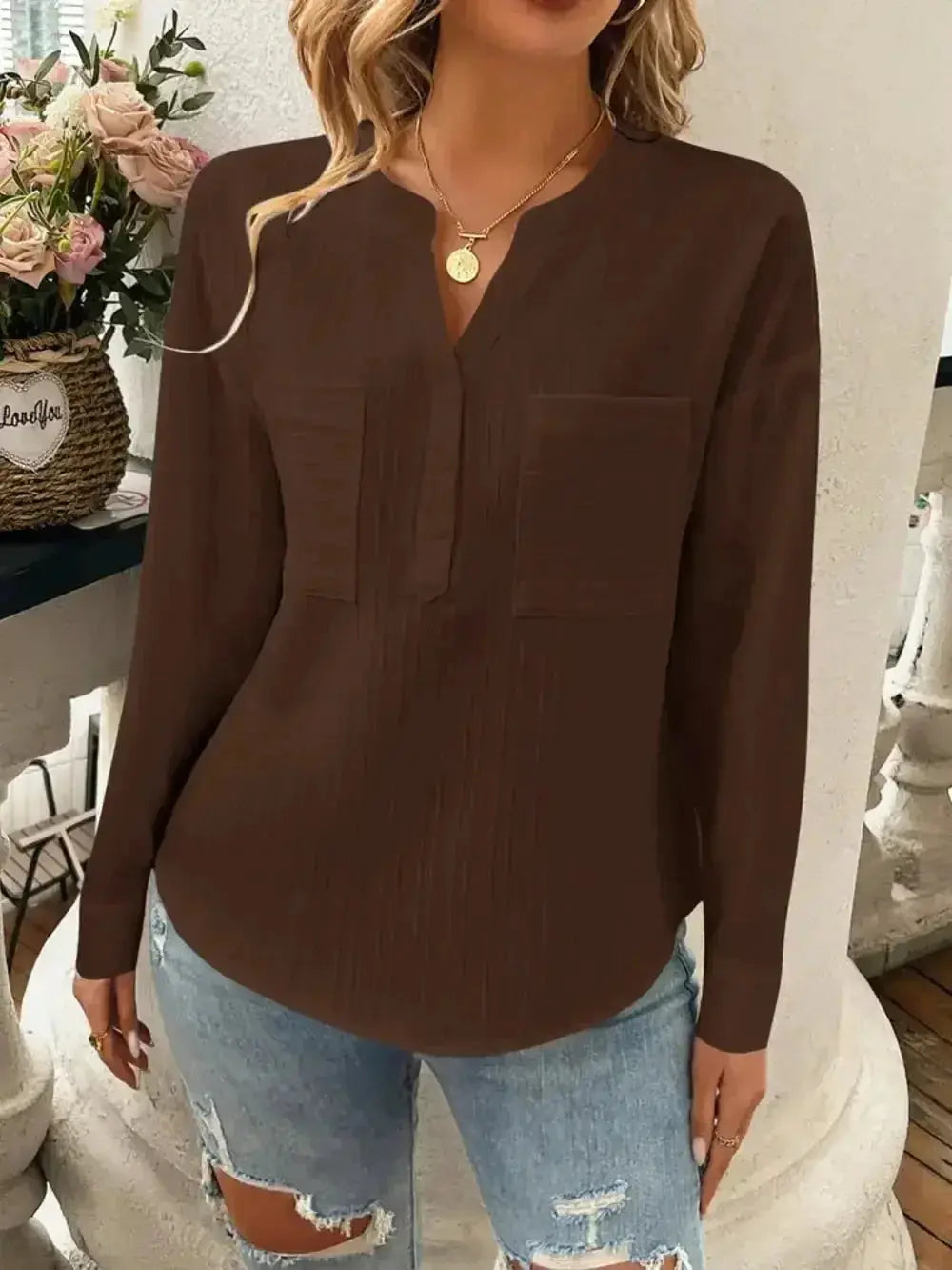 Brown long-sleeve V-neck blouse with front pockets paired with ripped jeans