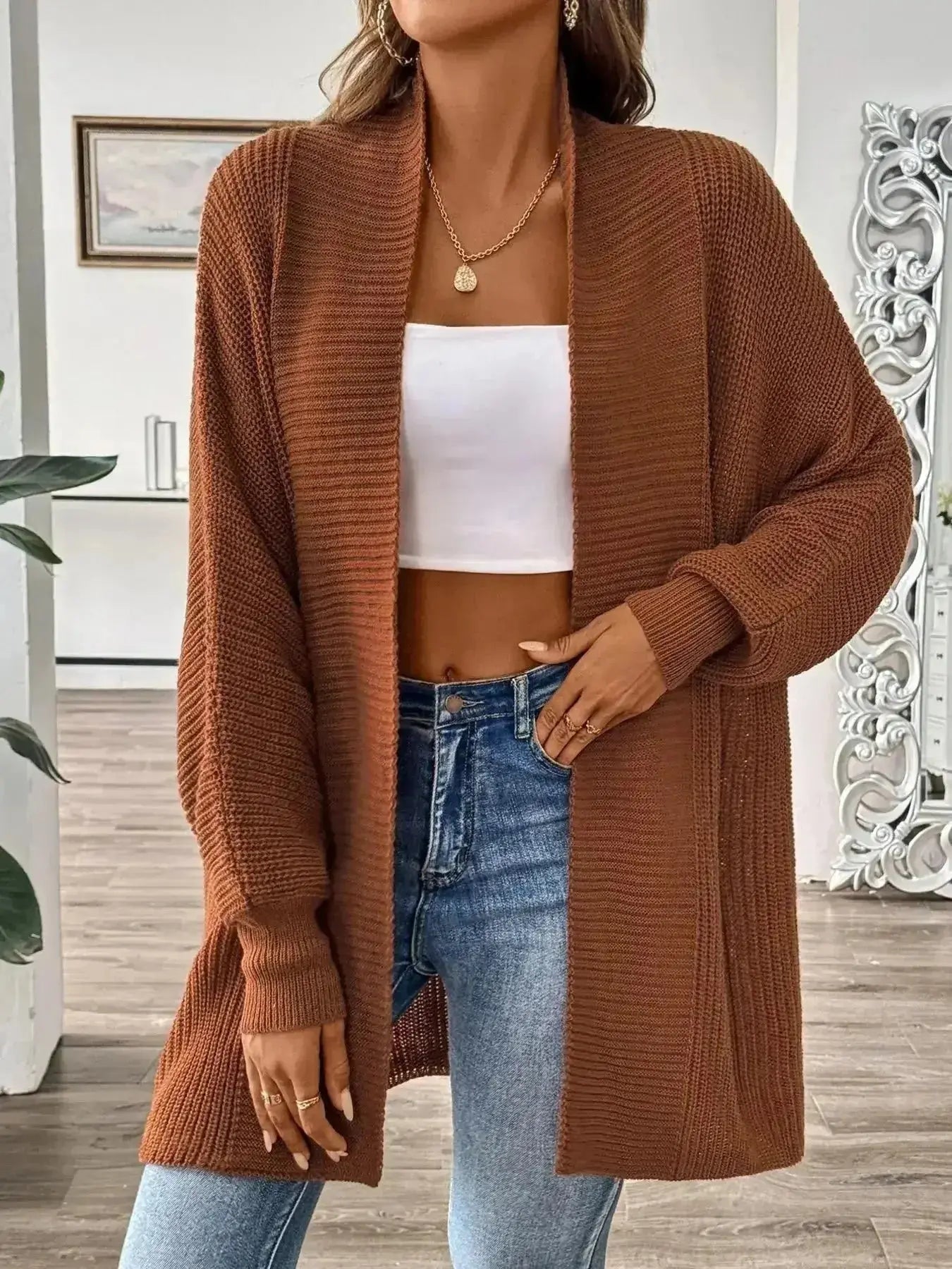 Brown ribbed knit cardigan with white crop top and blue jeans, modern minimalist style